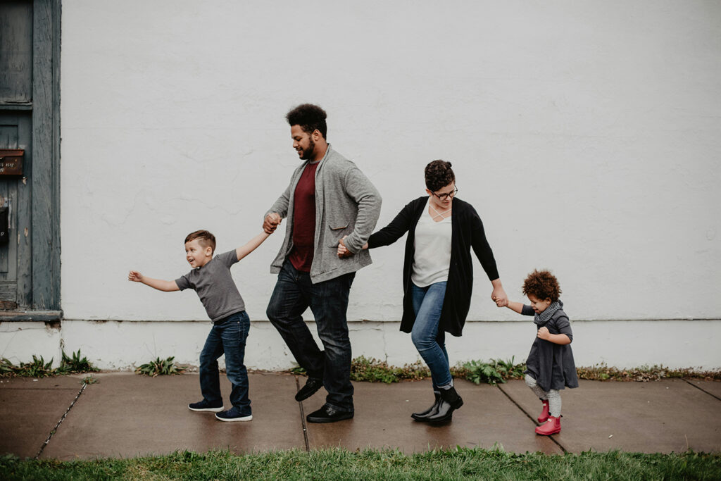 A happy young family with two children walking hand-in-hand, symbolizing hope, continuity, and the future amidst discussions of population decline.