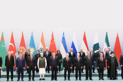 World leaders at the SCO Summit 2025 standing for a group photo with national flags in the background