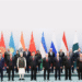 World leaders at the SCO Summit 2025 standing for a group photo with national flags in the background